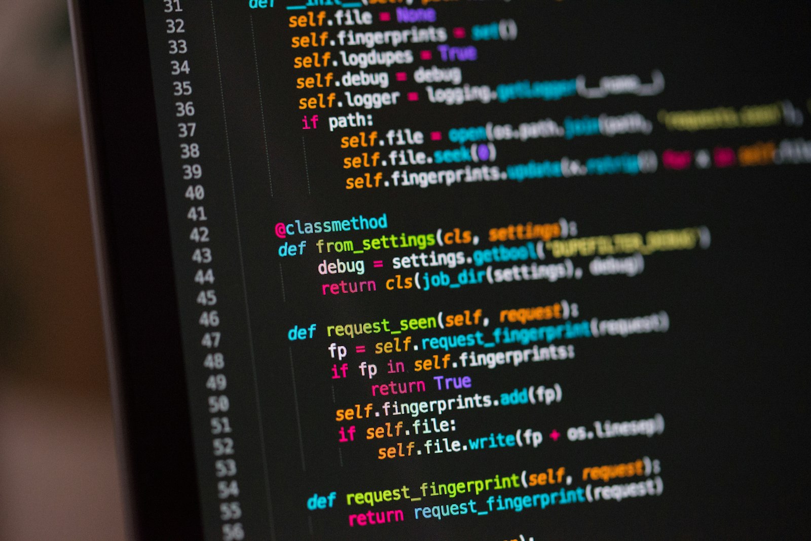 Code on a dark screen lit by ambient light